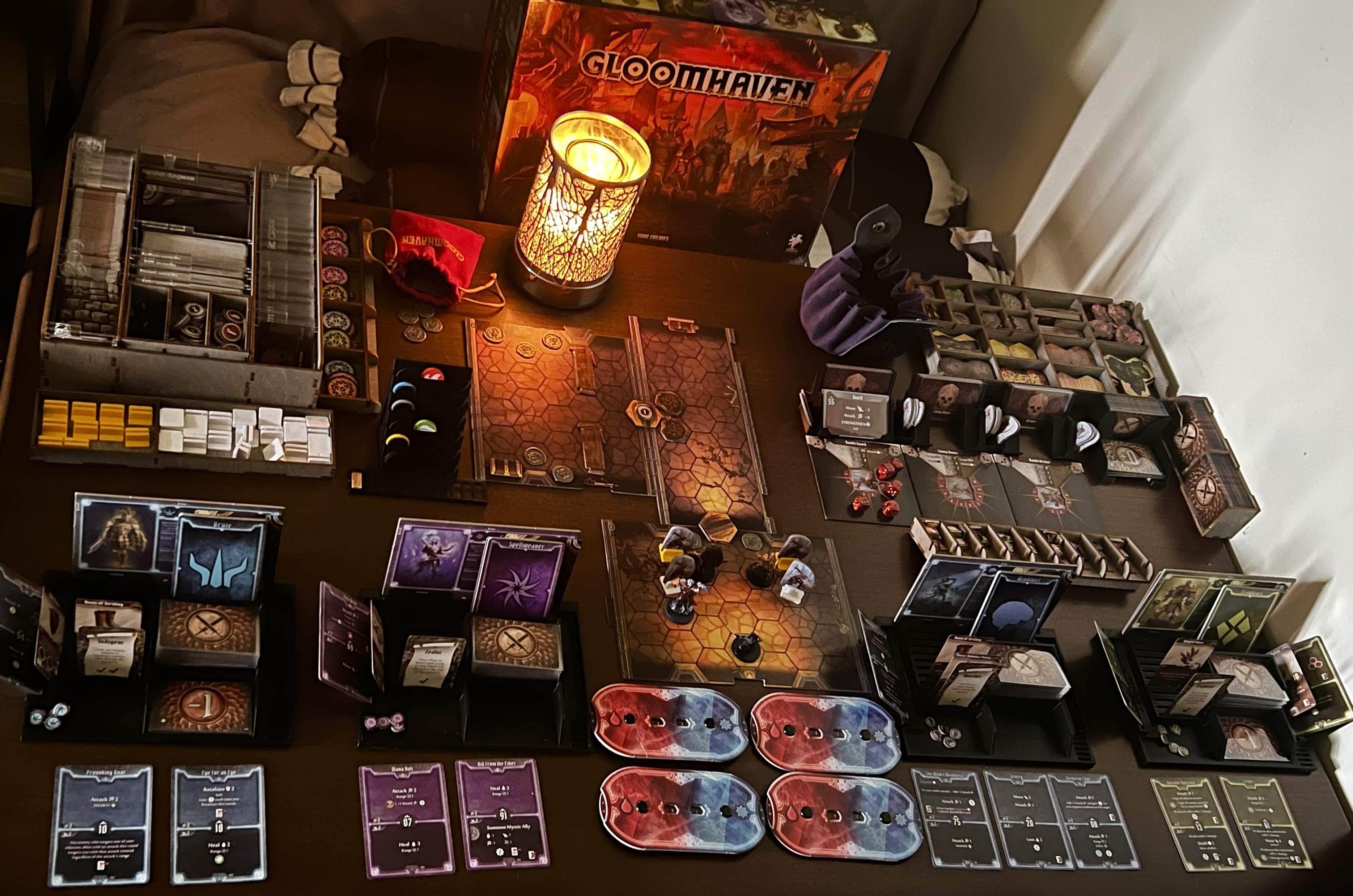 La boîte Gloomhaven dépliée sur une table : matériel, cartes, figurines, jetons et tuiles hexagonales